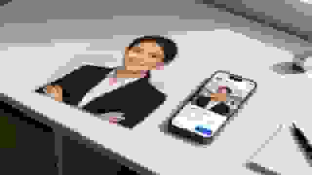 Professional headshot of a smiling real estate agent displayed on a print and a smartphone.