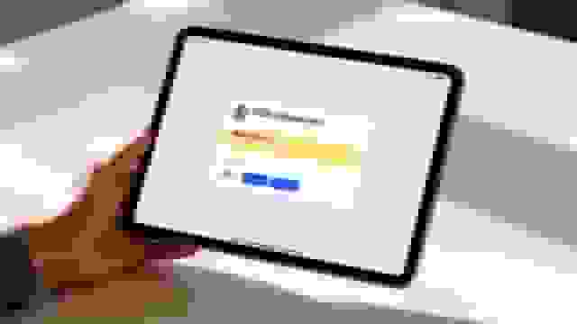 Person holding a tablet displaying a 'Profile Card' screen with 'Skills & Reccments' visible.