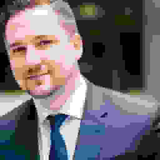 professional headshot of a white man with blue suit