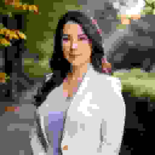 professional headshot of a white girl with white suit and park background